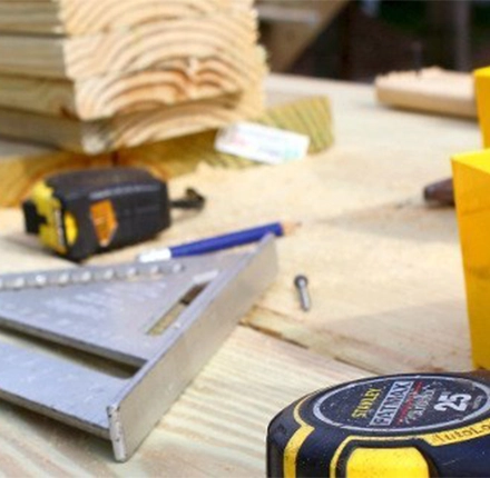 Werkzeuge und Holzbretter auf einer Baustelle – Präzision und Handwerkskunst bei der Holzmontage.