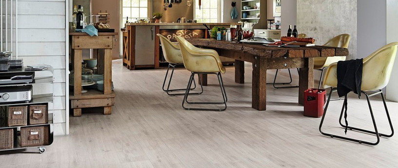 Moderner Küchenbereich mit hellem Vinyl-Designboden, rustikalem Holztisch und Stühlen.