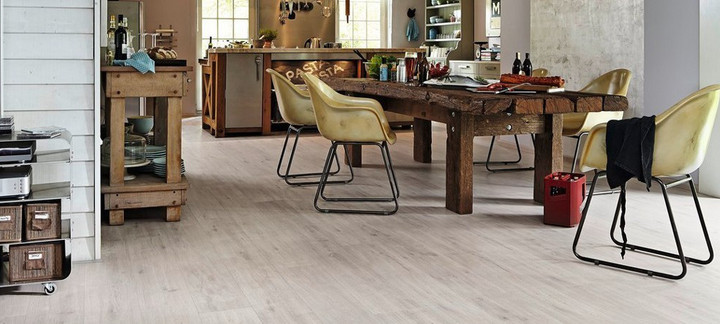 Moderner Küchenbereich mit hellem Vinyl-Designboden, rustikalem Holztisch und Stühlen.