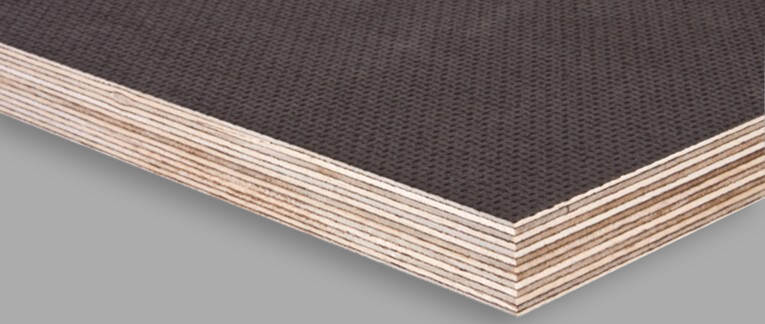 Nahaufnahme einer Siebdruckplatte mit rutschfester, dunkler Beschichtung, ideal für den Fahrzeugbau und den Außenbereich.