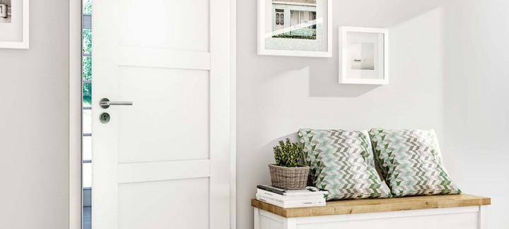 Weiße Innentür mit Edelstahlgriff, teilweise geöffnet, mit Blick auf Garten im Hintergrund.