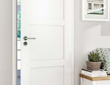 Weiße Innentür mit Edelstahlgriff, teilweise geöffnet, mit Blick auf Garten im Hintergrund.