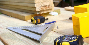 Werkzeuge und Holzbretter auf einer Baustelle – Präzision und Handwerkskunst bei der Holzmontage.